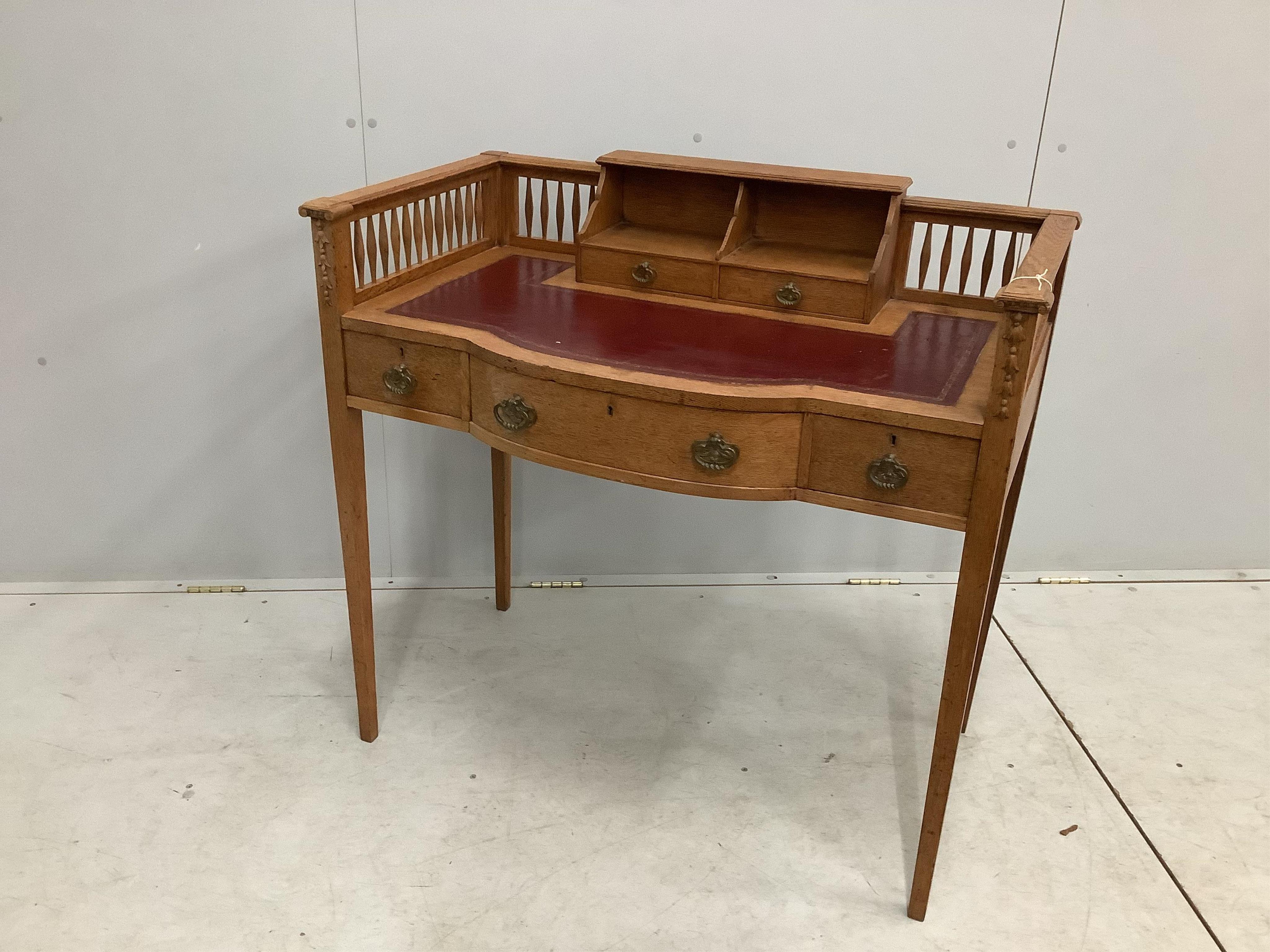 An early 20th century oak bow front writing table, width 95cm, depth 53cm, height 91cm. Condition - fair to good